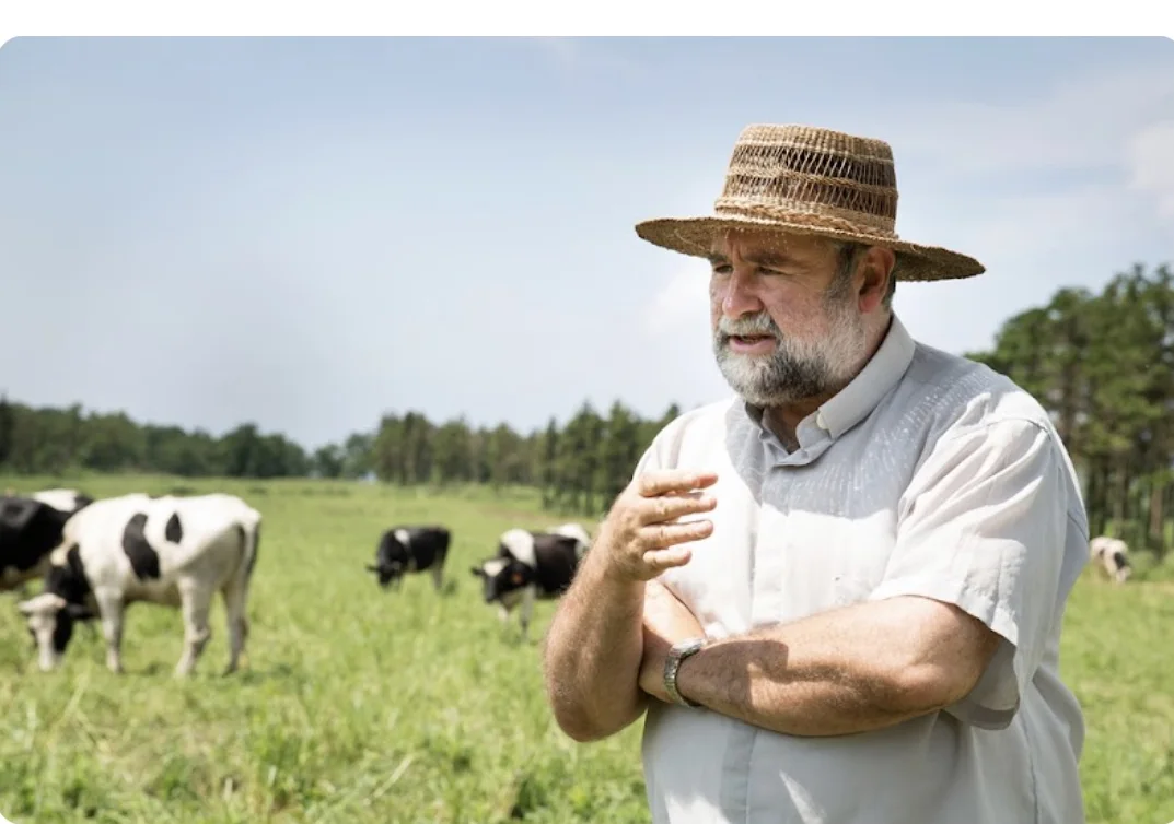 Fr. Michael Riordan standing with dairy cows at the ranch